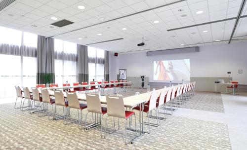 a conference room with a long table and chairs at Mercure Grenoble Centre Porte des Alpes in Grenoble