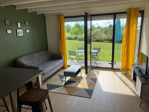 un salon avec un canapé et une table dans l'établissement Charmant appartement T3 avec terrasse en rez de jardin sur le Golf e L'Odet, à Bénodet