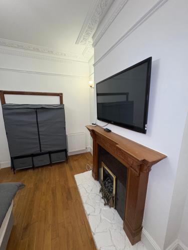 a living room with a tv and a fireplace at Cosy room 1 s in Streatham Vale