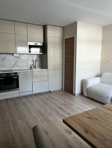 Il comprend un salon avec des placards blancs et une cuisine. dans l'établissement Agréable T2 avec terrasse et parking à La Rochelle - CAR13365HTR, à La Rochelle