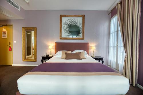 a hotel room with a large bed and windows at Hotel d'Aragon - Place de la Comédie in Montpellier