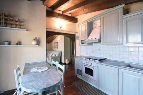 a kitchen with a table with chairs and a counter top at Lake Breeze Salò in Salò