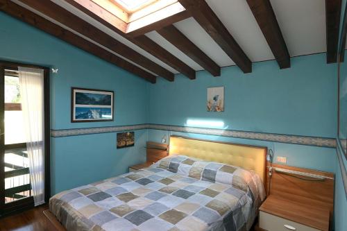 a bedroom with a bed with blue walls and a skylight at Lake Breeze Salò in Salò