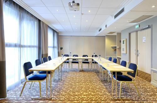 a conference room with a long table and chairs at Mercure Grenoble Centre Porte des Alpes in Grenoble