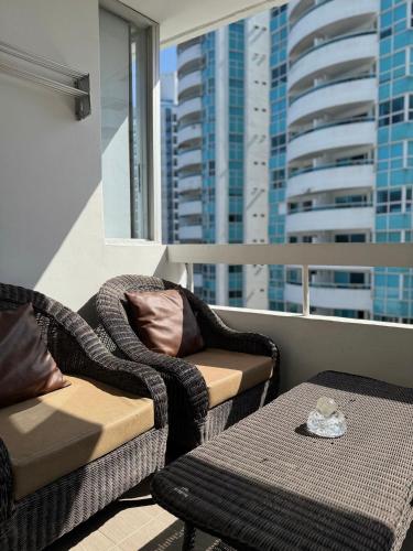 a balcony with two chairs and a table and a window at Polanco Residences Tocagua Cartagena - Colombia in Cartagena de Indias