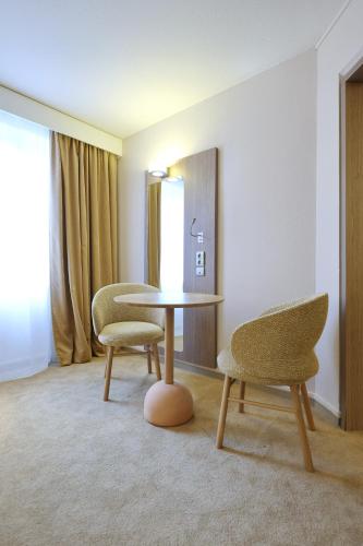 a room with two chairs and a table and two chairs at Mercure Grenoble Centre Porte des Alpes in Grenoble