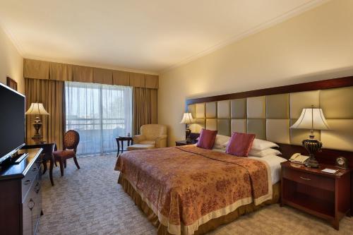 a hotel room with a large bed and a television at Grand Hotel Excelsior in Valletta