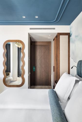 a room with a bed and a door with a mirror at One Shot Puerta Ruzafa in Valencia