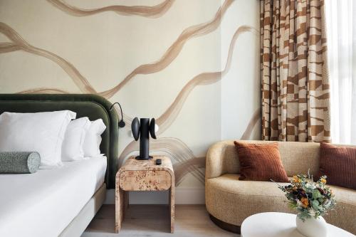 a bedroom with a bed and a couch and a chair at One Shot Puerta Ruzafa in Valencia