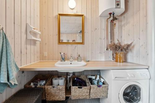 a bathroom with a sink and a washing machine at Charming Holiday Home Near Stenstrup Beach in Nykøbing Sjælland