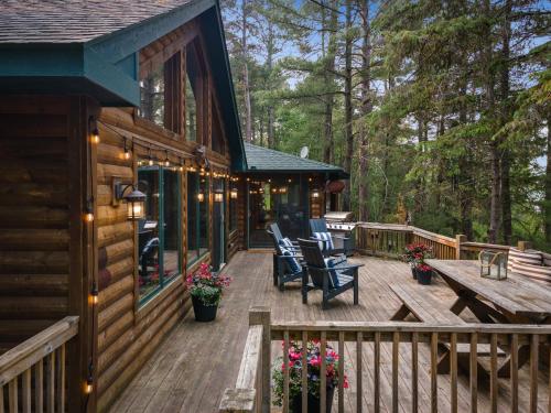 a wooden deck with chairs and a table on a cabin at Valhalla on Bass Lake in Pequot Lakes