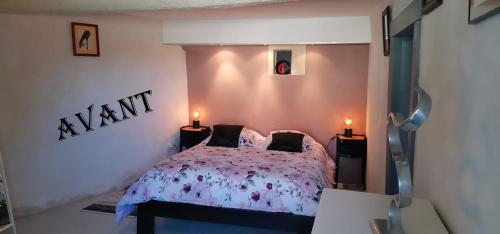 a bedroom with a bed with a purple comforter at Chambres d'hôtes des Princes de Bel Air in Loudun