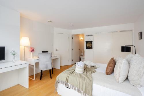 a white room with a bed and a desk at Majestic Villa in Downtown Griffintown in Montréal