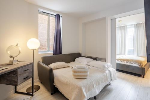 a bedroom with a bed with a desk and a bed sidx sidx sidx at Majestic Villa in Downtown Griffintown in Montréal