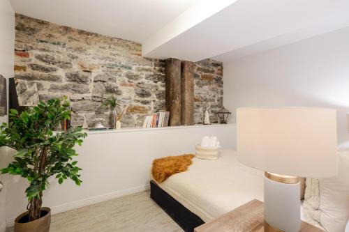 a bedroom with a bed and a brick wall at Majestic Villa in Downtown Griffintown in Montréal
