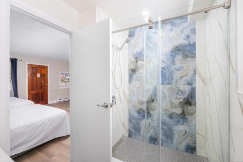 une salle de bain avec une douche avec une porte vitrée dans l'établissement Lions Head Beach Motel & Cottages - WATERFRONT, à Lion's Head