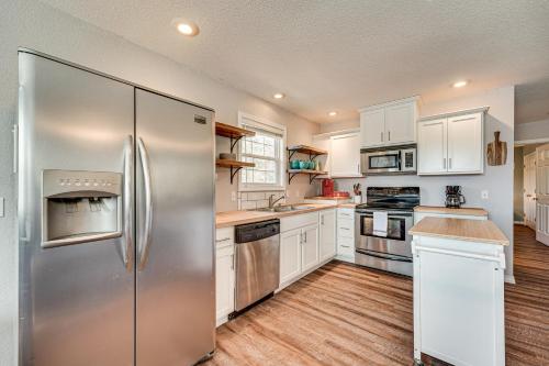 a kitchen with white cabinets and a stainless steel refrigerator at Branson Area Home Less Than 1 Mi to Table Rock Lake! in Kimberling City
