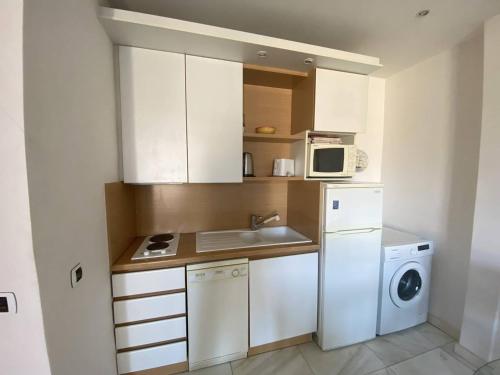 Il comprend une petite cuisine équipée d'un lave-linge et d'un four micro-ondes. dans l'établissement 540 Cannes La Croisette - Joli studio au calme coté jardin, à Cannes