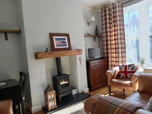 a living room with a wood stove and a couch at Woolly Hill House - Beautiful Townhouse in the Heart of Wooler in Wooler