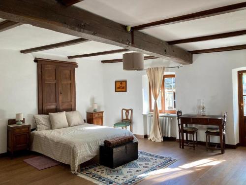 a bedroom with a bed and a desk in it at Maison Garavet in Donnaz