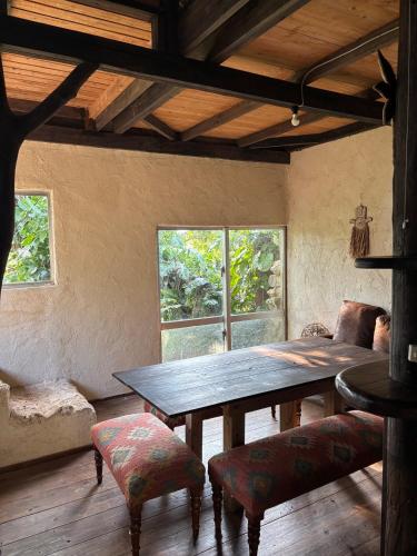 a dining room with a table and chairs and a bed at HiddenVilla in Nakijin