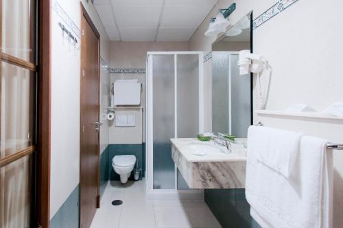 a bathroom with a sink and a toilet at Hotel Restaurante Blanco y Verde in Conil de la Frontera