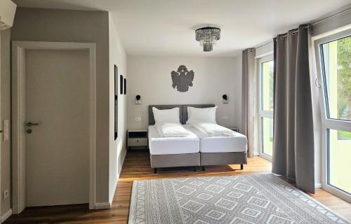 a bedroom with a white bed and a window at Der Franzlhof in Laxenburg