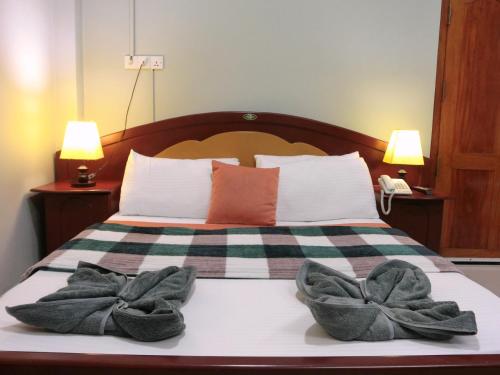a bedroom with a bed with two towels on it at SATK INN Jaffna, Kokkuvil in Kokkuvil East