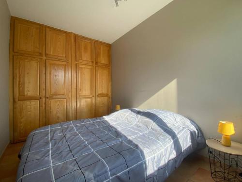 a bedroom with a bed and wooden cabinets at Villa landaise à 9km de l'Océan in Saint-Julien-en-Born
