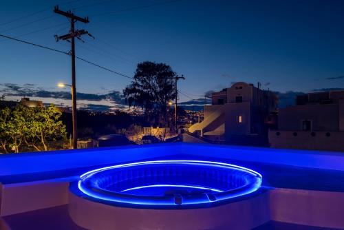 a blue lighted bath tub on a balcony at night at Aerenia Luxury Suites in Karterados