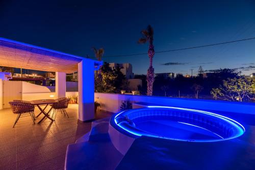 a hot tub in the backyard of a house at night at Aerenia Luxury Suites in Karterados