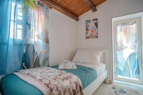 una piccola camera da letto con un letto e una finestra di La Casetta di Dandrì a Monreale