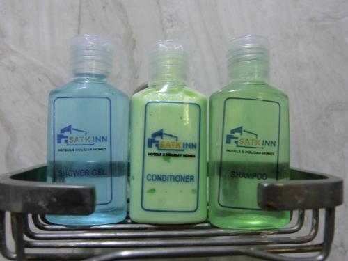 two bottles of detergent sitting on a metal shelf at SATK INN Jaffna, Kokkuvil in Kokkuvil East