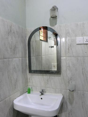 a white bathroom with a sink and a mirror at SATK INN Jaffna, Kokkuvil in Kokkuvil East
