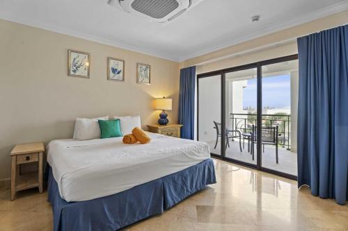 a bedroom with a large bed and a balcony at PC410 - Pool View - Perfect for families or group - Close to Palm Beach - 2BR in Palm-Eagle Beach