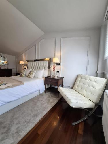 a bedroom with a large white bed and a couch at Duplex A Mosquera by Foroplaza Pleno centro Vistas muralla in Lugo