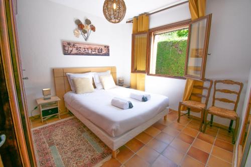 une chambre avec un lit, une chaise et une fenêtre dans l'établissement Villa Ma Rosa, 160m2, 4ch, Piscine et Jardin, à Mandelieu-la-Napoule