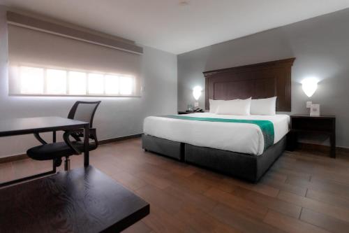 a hotel room with a large bed and a desk at InHouse Hotel Obregón in Ciudad Obregón