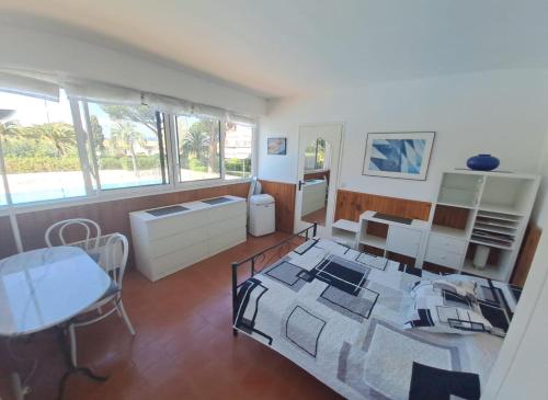 Großes Zimmer mit einem Bett und einem Tisch sowie einem Tisch und Stühlen. in der Unterkunft TROPCOQ - Au coeur de St-Tropez - Studio cabine pour 2 personnes in Saint-Tropez