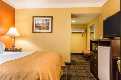 a hotel room with a bed and a flat screen tv at Hamden Hotel and Suites HAMDEN - NEW HAVEN in Hamden