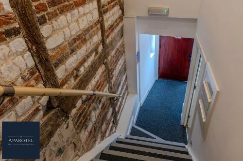 a stairway with a brick wall and a red door at Aparotel Serviced Apartments - Stonehenge, Amesbury Town Centre in Amesbury