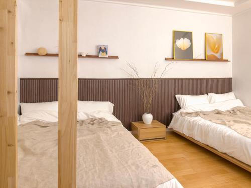 a bedroom with two beds and a wooden headboard at STAY ONDAM #3room #10guests in Seoul