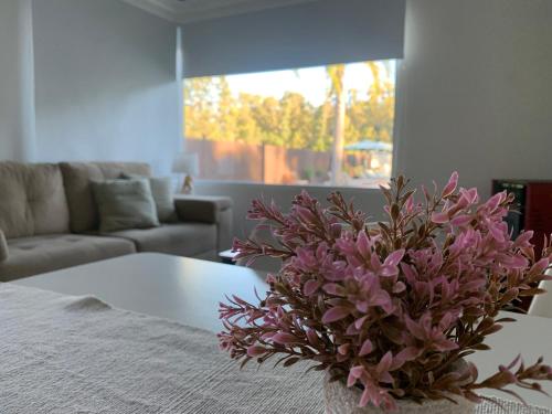 a vase of purple flowers sitting on a table in a living room at Vista24uy Ref1003 in Bella Vista