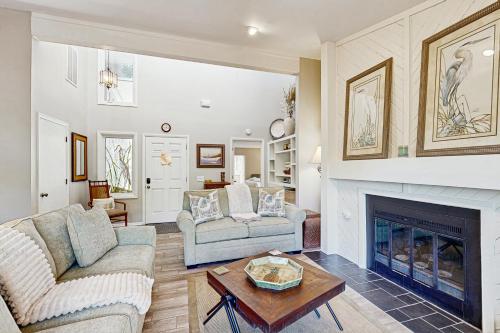 a living room with two couches and a fireplace at Surfscoter 94 in Kiawah Island