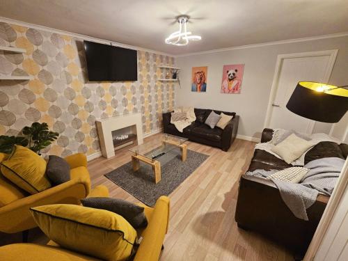 a living room with a couch and a fireplace at Platt House in Wigan