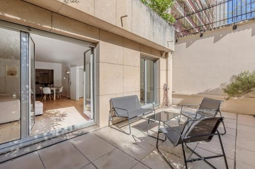 d'une terrasse avec 2 chaises et une table en verre. dans l'établissement Beautiful 4P Apartment with Garden - Paris 16th, à Paris