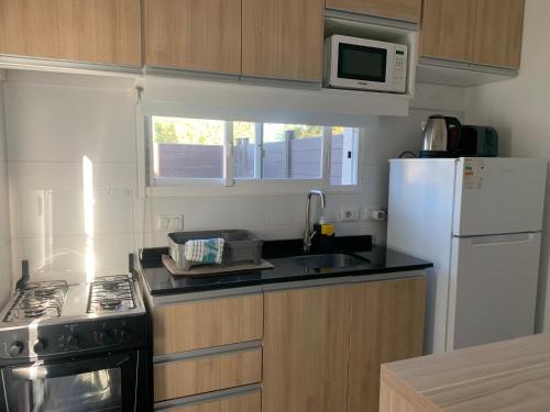 a small kitchen with a stove and a refrigerator at Vista24uy Ref1003 in Bella Vista