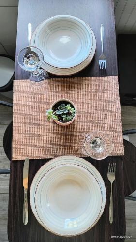 a wooden table with plates and utensils on it at Tiny house experience in Rungue