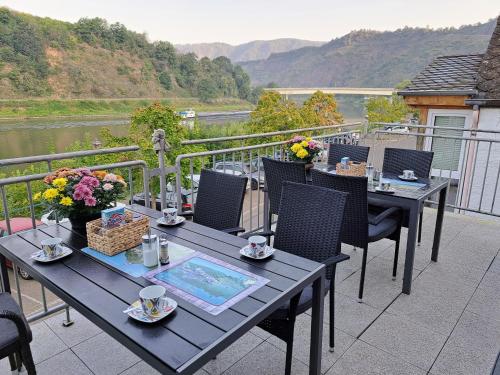 a table and chairs on a balcony with a view of a river at Gästehaus Mona Lisa in Neef