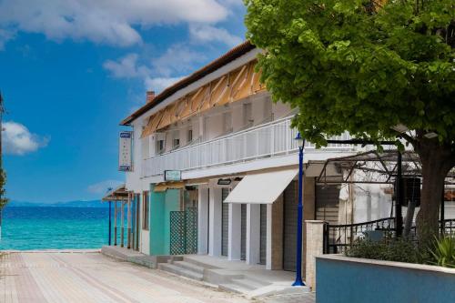 a building on the beach next to the ocean at Galini apartments Polyhrono in Kassandria